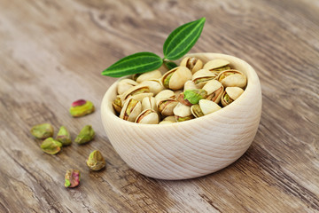 Pistachio nuts in wooden bowl with copy space
