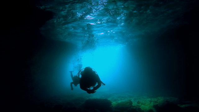 Scuba Divers Exploring an Underwater Cave
