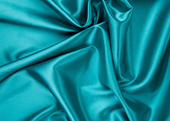 Soft folds of deep blue silk cloth texture.