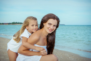 Fototapeta premium Happy beautiful mother and daughter enjoying beach time