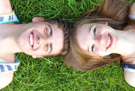 Young happy couple lying in grass