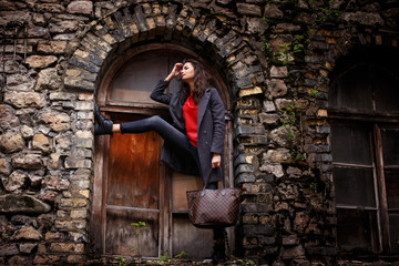 Fototapeta na wymiar Slender girl posing on brick wall background