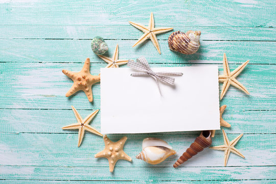 Empty tag and marine items on wooden background. Sea objects on turquoise painted wooden planks. Selective focus. Place for text. .