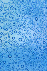 Fototapeta na wymiar blue waterdrops on glass surface