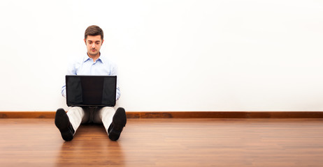 Man using a laptop while sitting on the floor