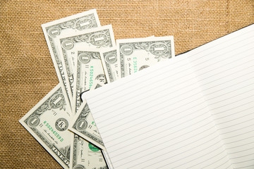 Opened notebook and money on the old tissue