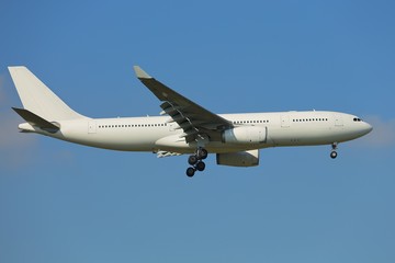 Plane landing against clear blue sky