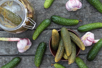 Closeup of some pickled and fresh cucumbers.