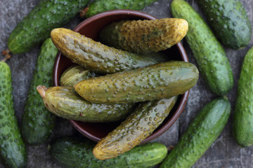 Closeup of some pickled and fresh cucumbers.