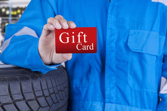 Workshop worker holds a gift card