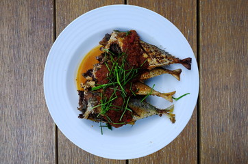 fried fish and chili sauce on wooden table, thai food
