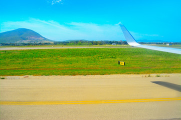airplane wing over a taxiway