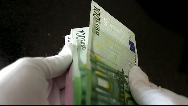 hands counting euro banknotes