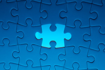Missing jigsaw puzzle piece with light glow