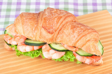 sandwich with shrimp salad on a wooden cutting board