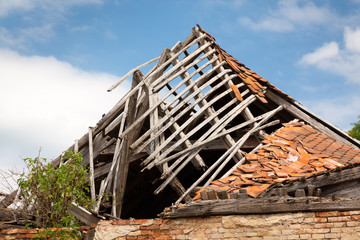 Ruined brick/wooden house - destroyed roof, vegetation.