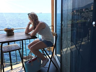 Ragazza seduta che guarda dal balconel sul mare