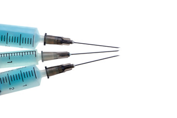 Three plastic disposable syringes with a metal needles with blue