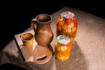 Jars of Pickles on Table with Wooden Handicrafts