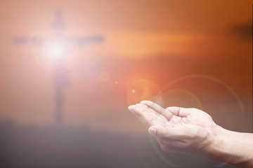 Praying Hand and the cross blurred background