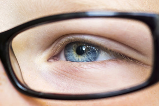 Eye in glasses close up