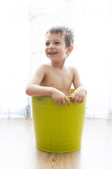 kid bathing in a green bucket