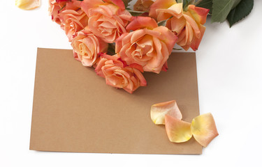 A sheet of old brown paper with rose petals and tender tea roses
