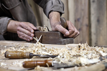 Fototapeta na wymiar hands of carpenter plane on the workbench in carpentry