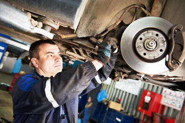 auto mechanic at car brake shoes eximining
