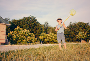 Cute funny little boy running to catch butterflies
