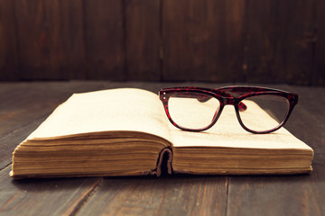 Vintage reading glasses on the open book