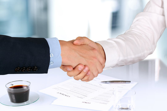 Close-up image of a firm handshake  between two colleagues under