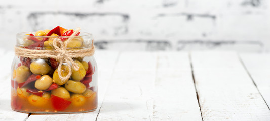 glass jar with olives and peppers