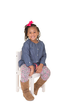 Cute School Aged Child Sitting On A Chair