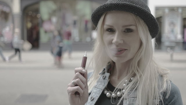 woman smoking e-cigarette in the city 