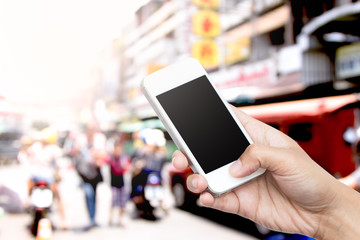 woman hand hold smart phone, tablet,cellphone on blur traffic an