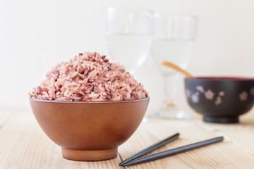 Bowl of steamed brown rice on wood table