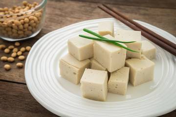 Tofu cubes on plate and soy beans in bowl