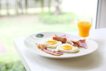 Breakfast with bacon , fried egg and orange juice