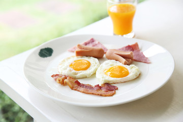 Breakfast with bacon , fried egg and orange juice