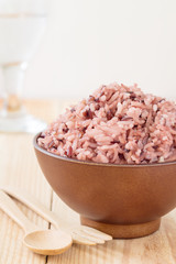 Bowl of steamed brown rice on wood table