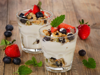 Yogurt with Granola  and fresh berries on  a wooden background.