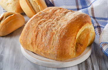 Loaf of bread on a white  cutting board.