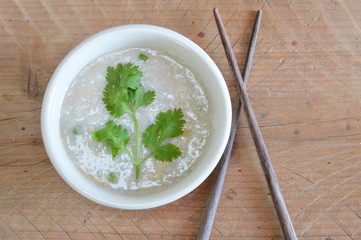 parsley on rice porridge and wood chopstick