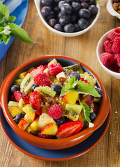 Healthy homemade fruit salad on   rustic wooden background.