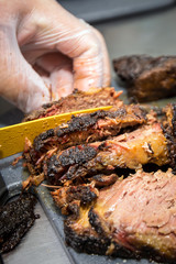 Barbecue pitmaster cuts through a delicious cut of beef brisket