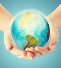 close up of human hands with earth globe