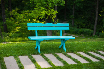 Fototapeta premium Blue bench in the garden near the track, summer, grass, recreation