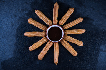 Fried churros with chocolate dip, mexican sun