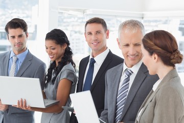Business colleagues showing their multimedia devices to each oth